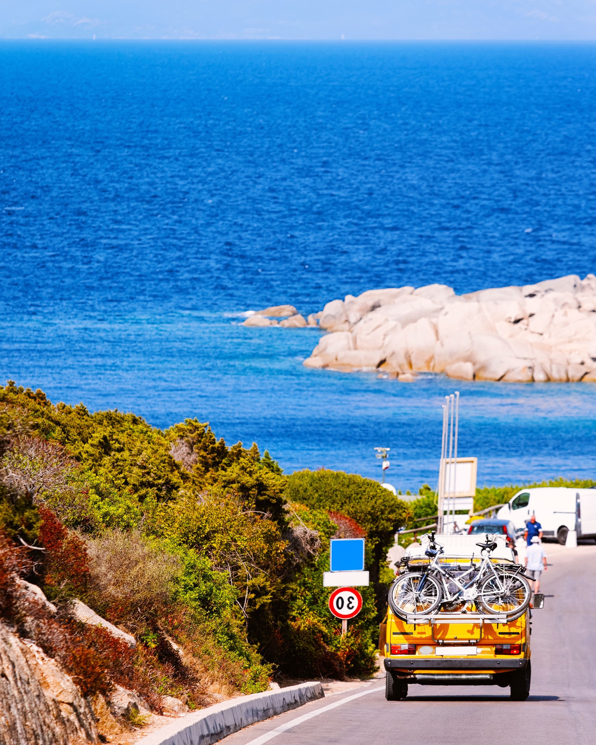 Mietwagen fährt entlang der Küstenstraße von Sardinien mit Blick auf das Meer